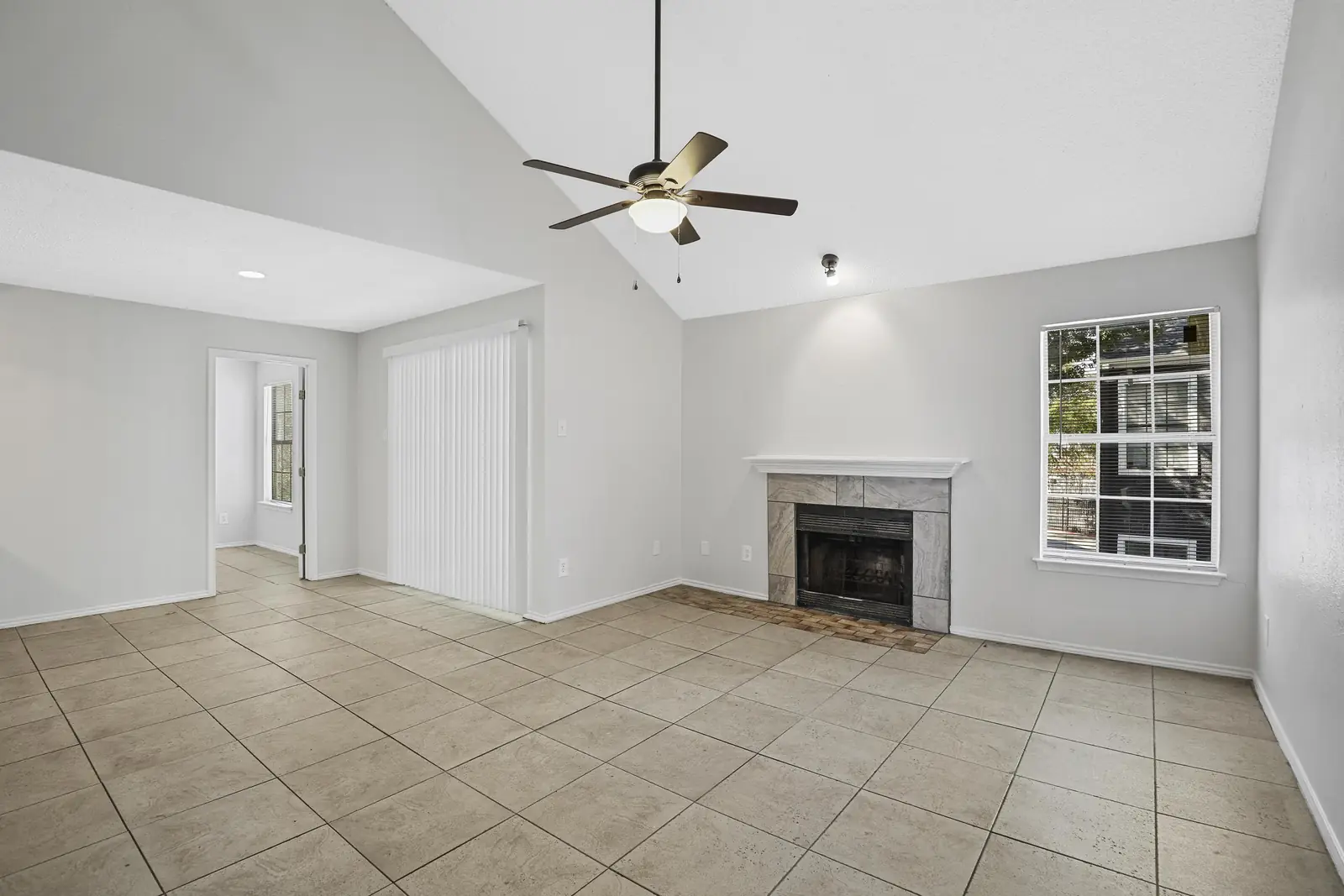 Open living room with vaulted ceiling and wood-burning fireplace