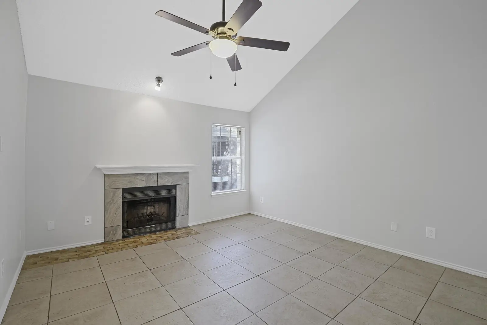 Tiled fireplace and ceiling fan in the living room