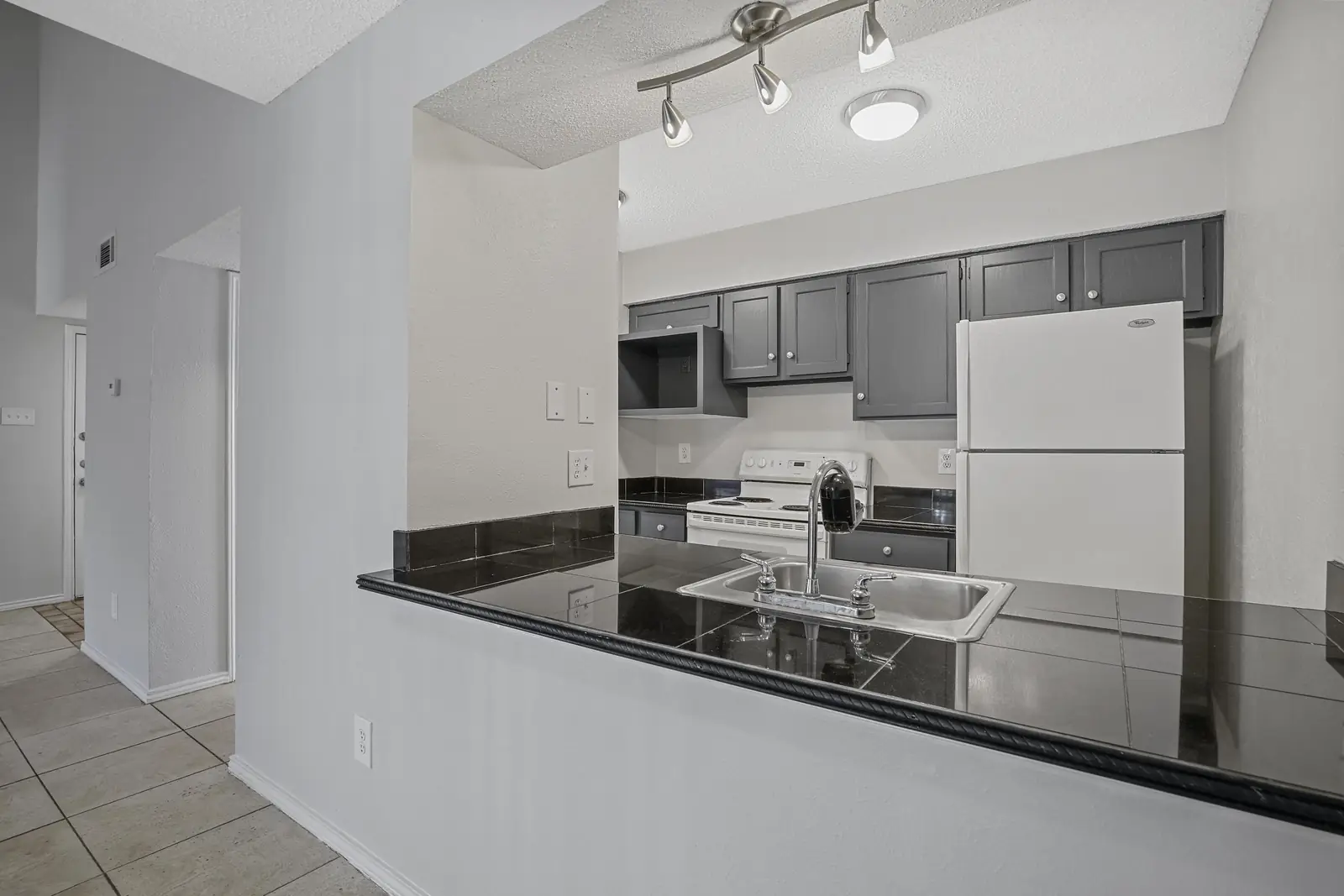 Kitchen with dark counters and breakfast bar seating