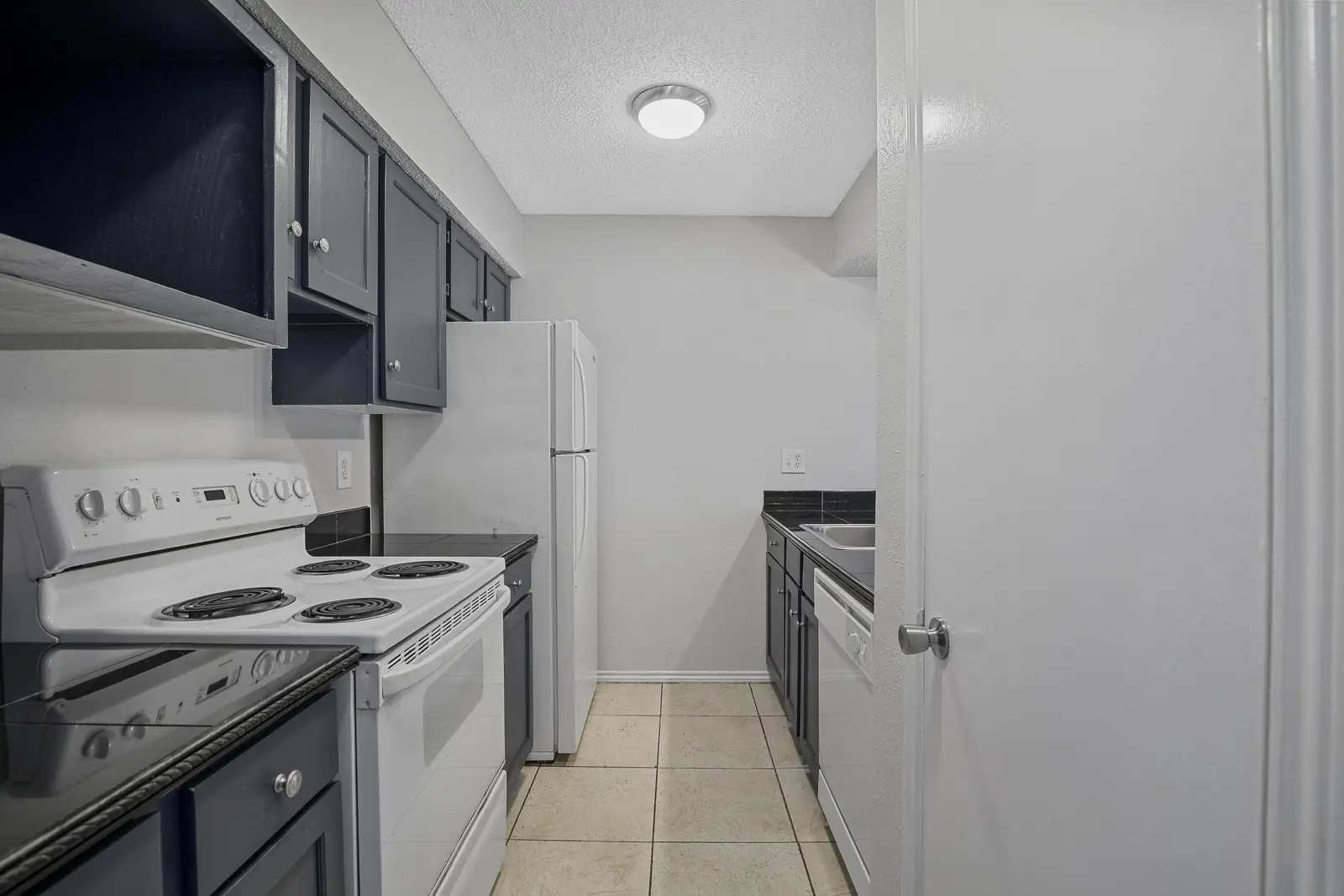 Full kitchen with range, refrigerator and ample cabinets