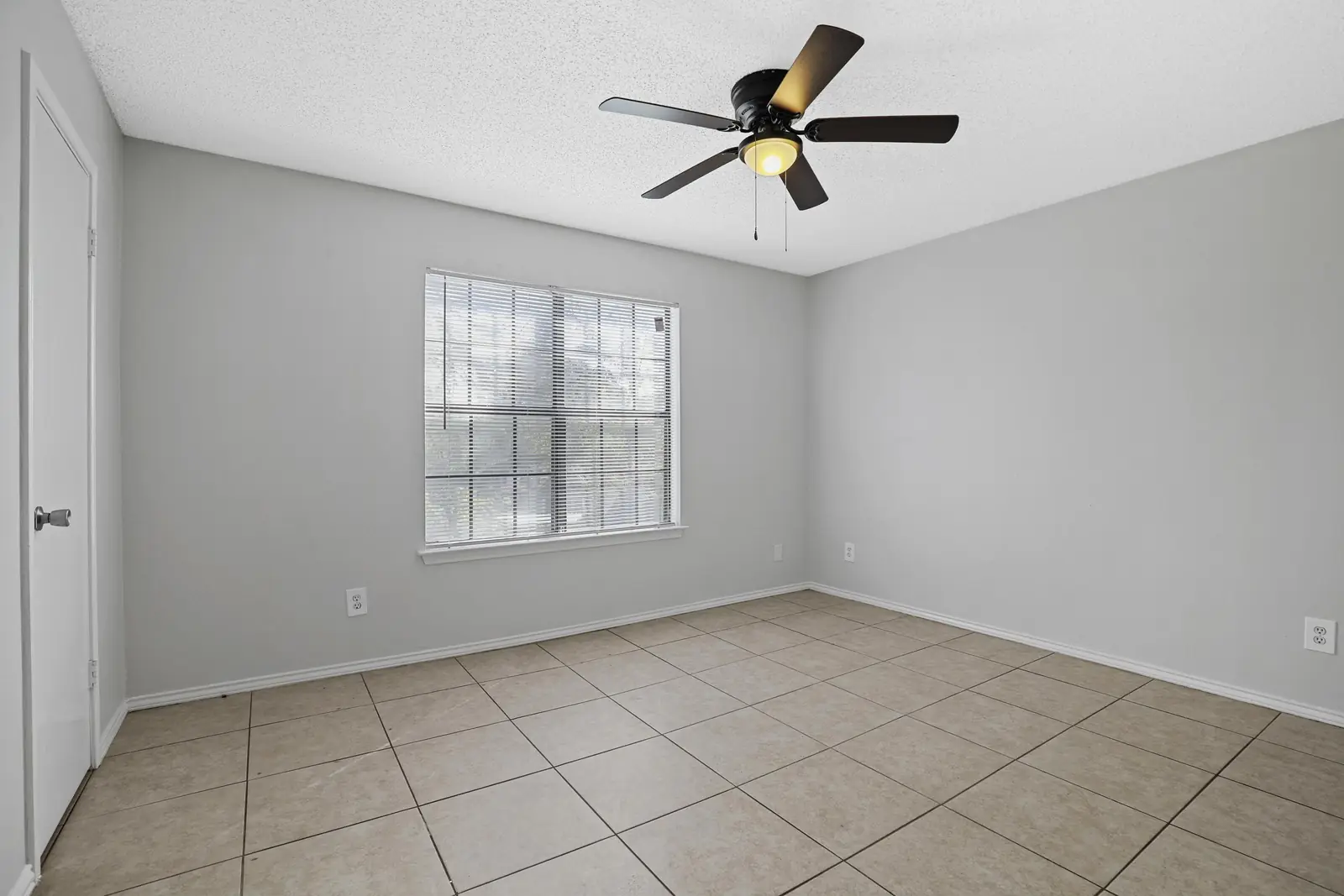 Bedroom with large window and ceiling fan