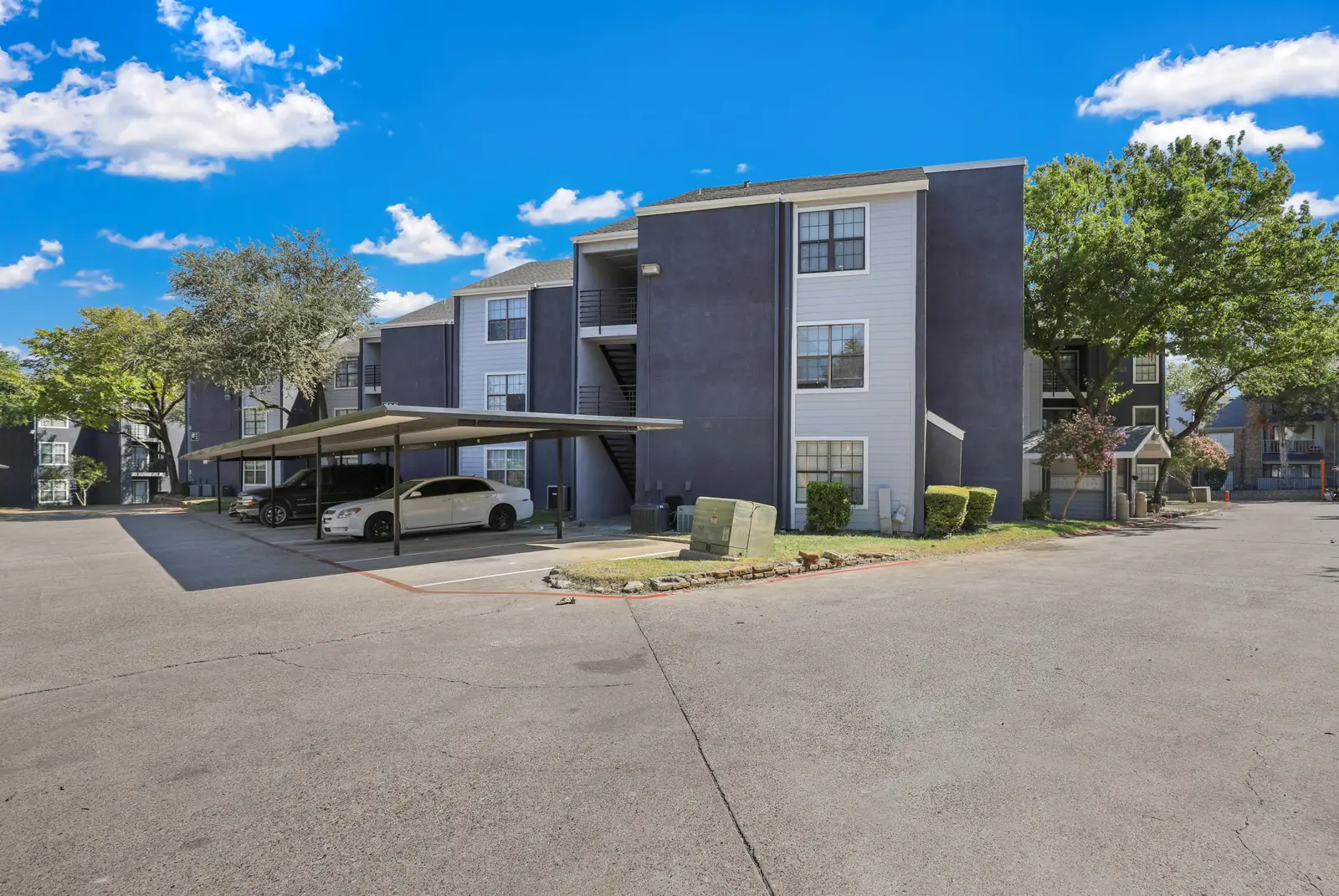 Village Oaks apartment building and covered resident parking
