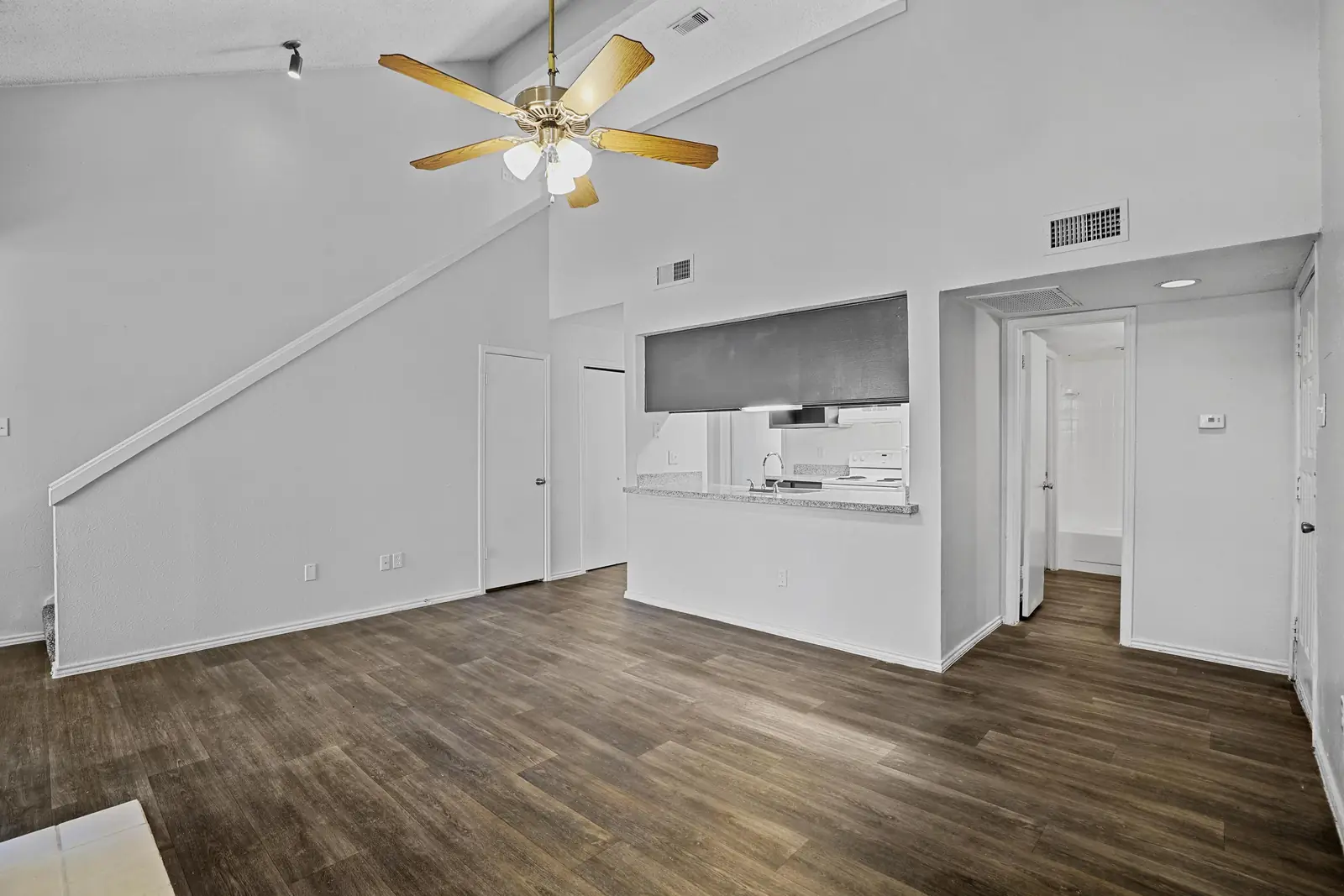 Vaulted townhome living space with ceiling fan