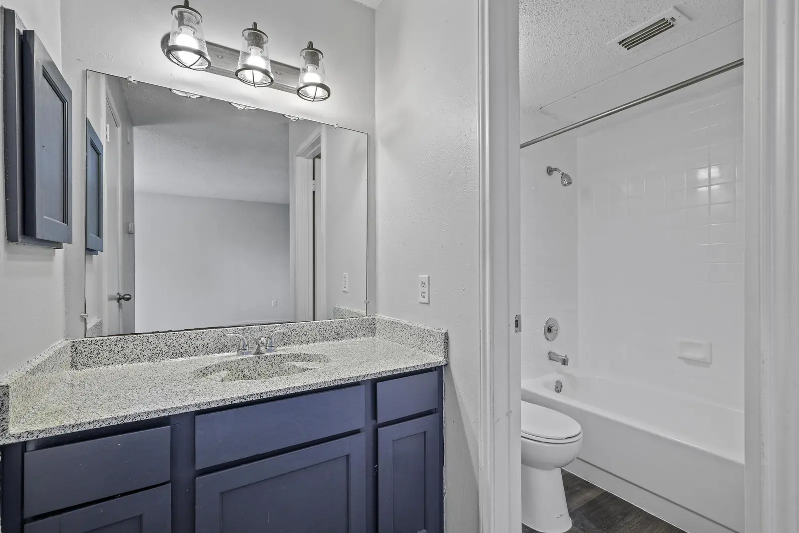 Vanity with large mirror and modern lighting